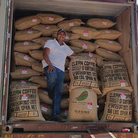 Betio Reyes and a shipment of freshly processed green coffee before shipment to Ozone coffee in the UK.